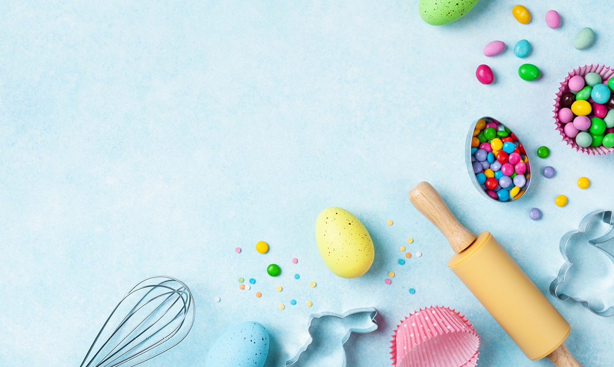 Easter eggs and cooking utensils on a light blue background