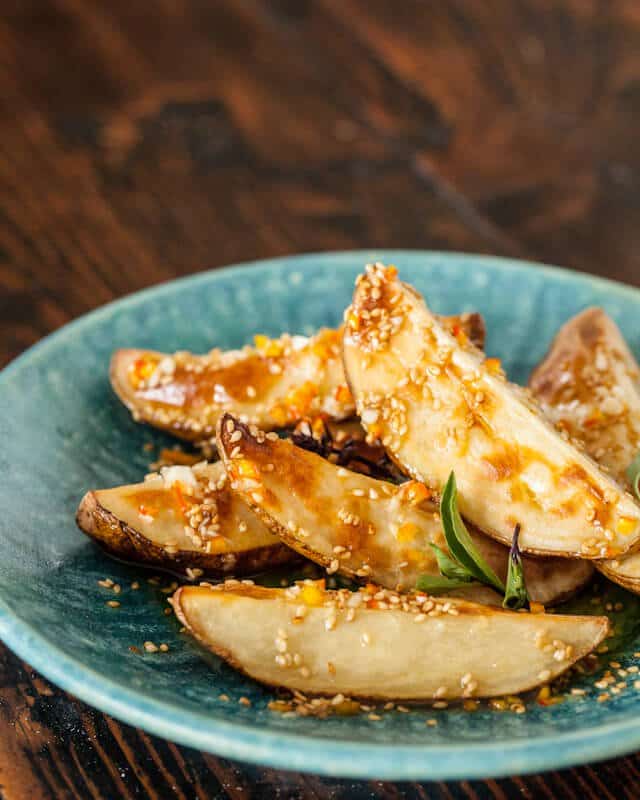 Asian roasted potato salad on a blue plate