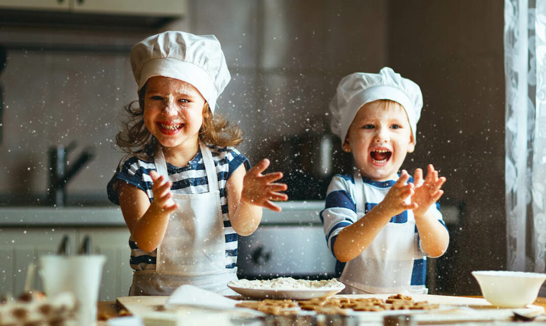 Happy family funny kids bake cookies in kitchen