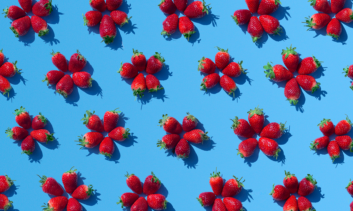 Strawberries stacked like flowers on a blue background