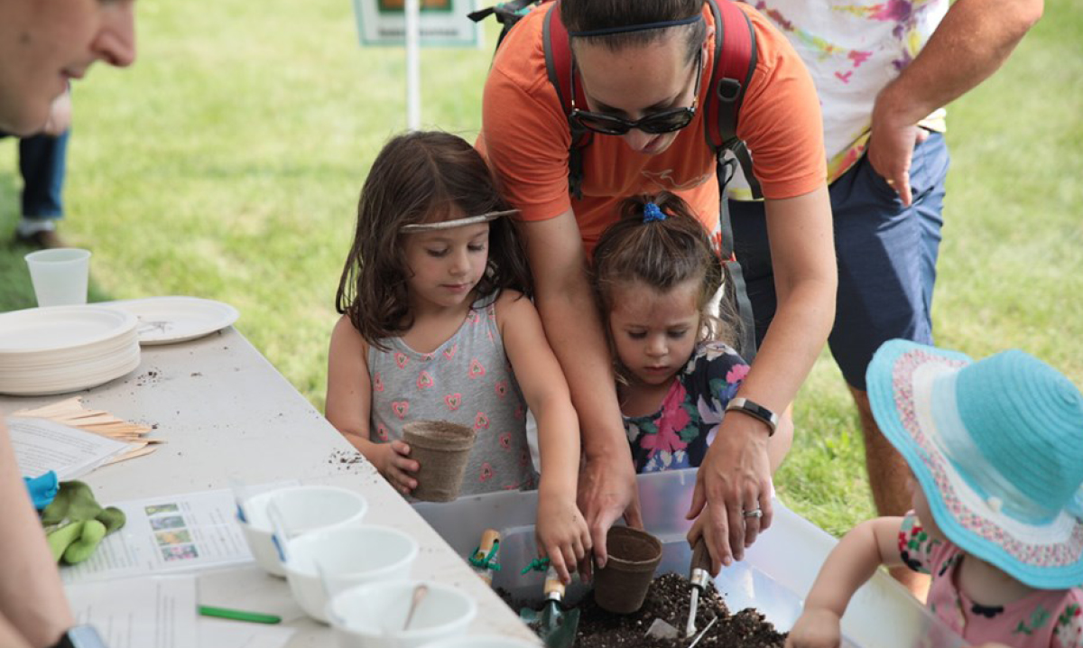 Girl and woman planting a plant at Saline's Summerfest