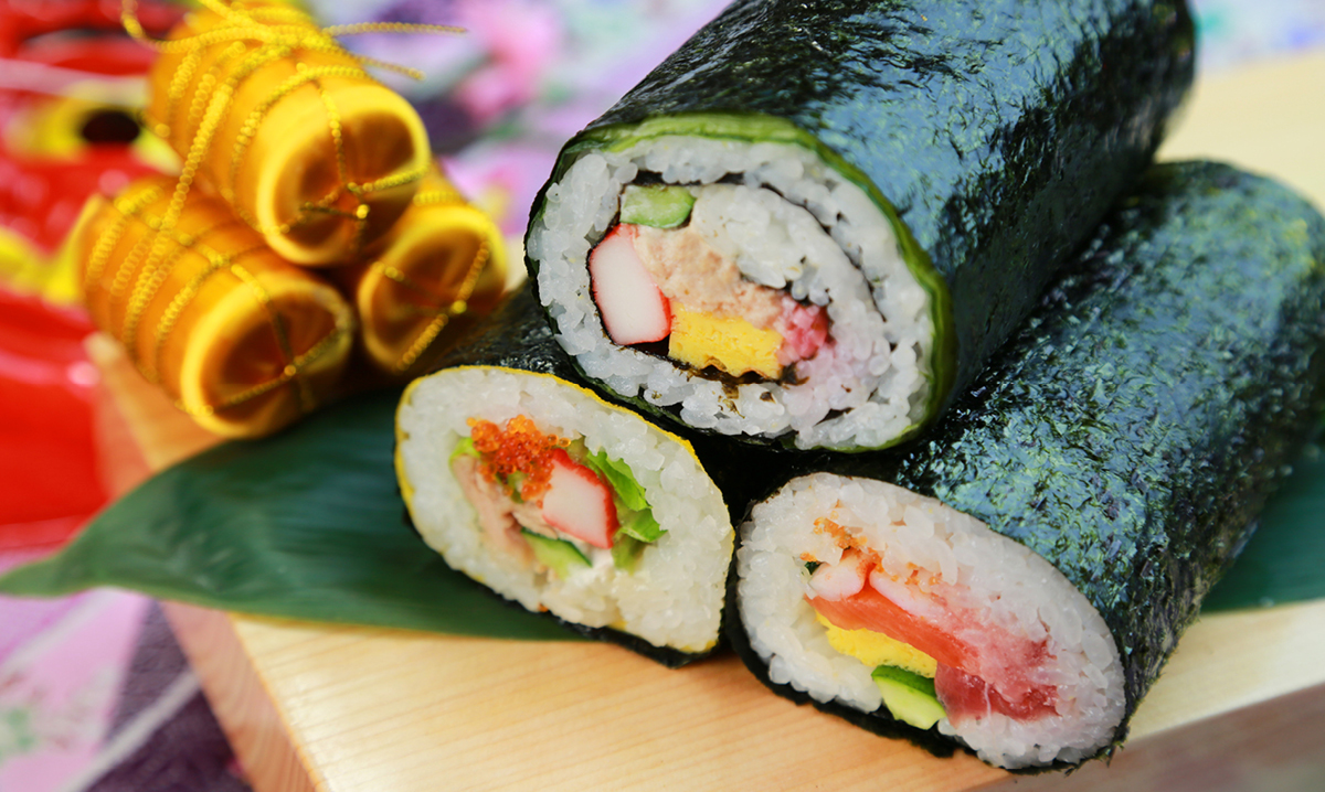 Rolled sushi on a brown cutting board