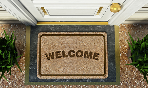 Door mat with welcome word standing in front of the house door