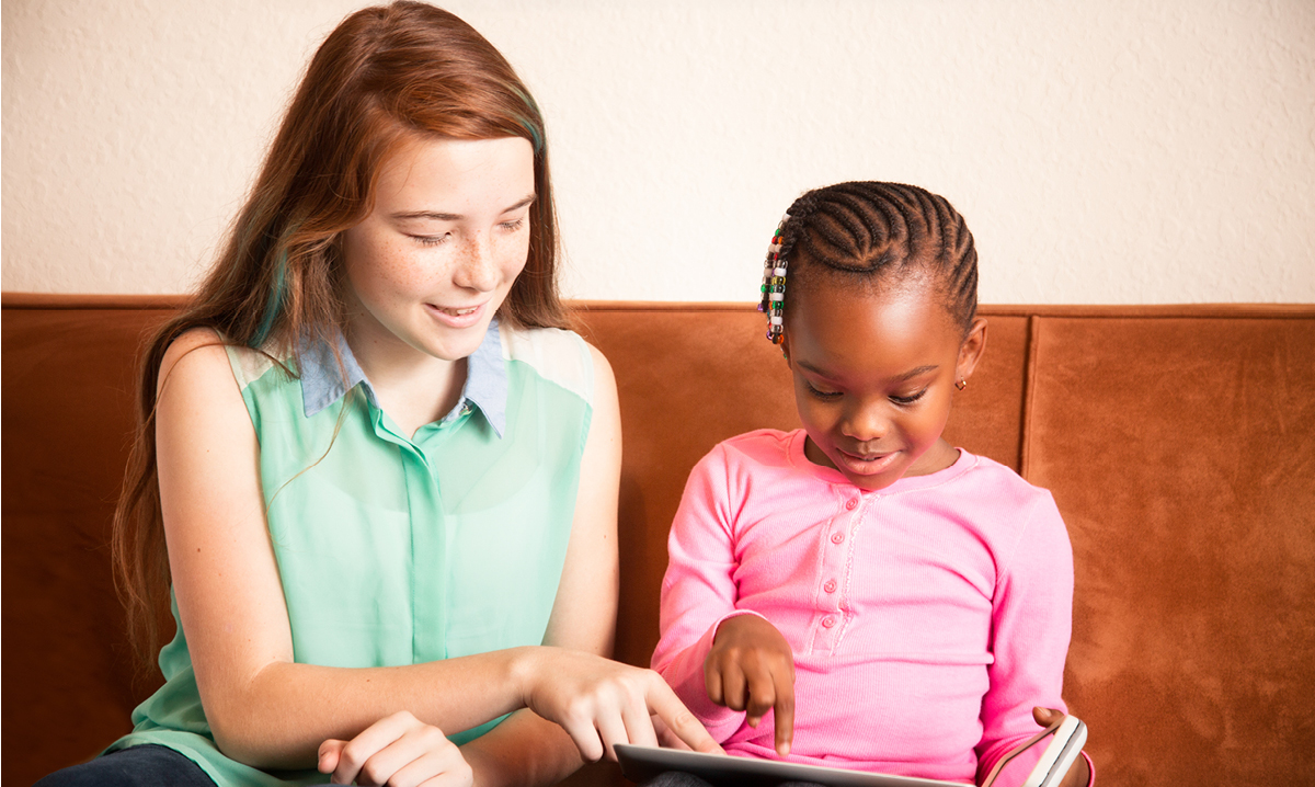 Babysitter helping a little girl read