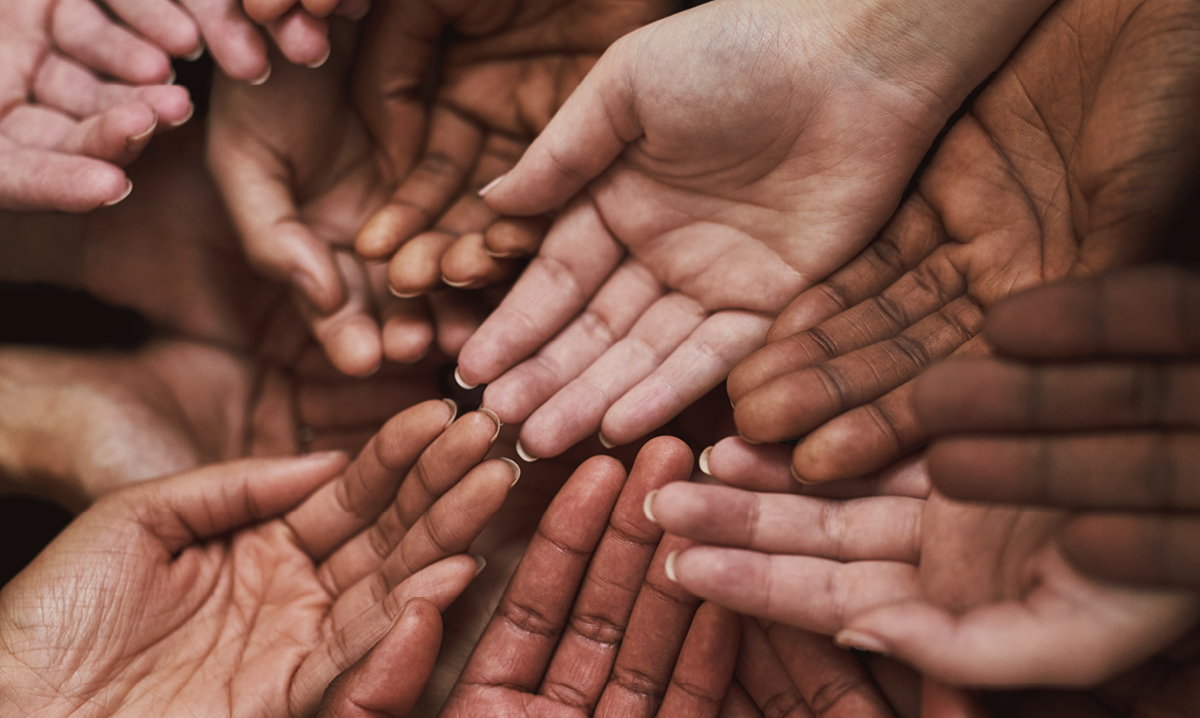 Hands with different skin tones with touching with palms up