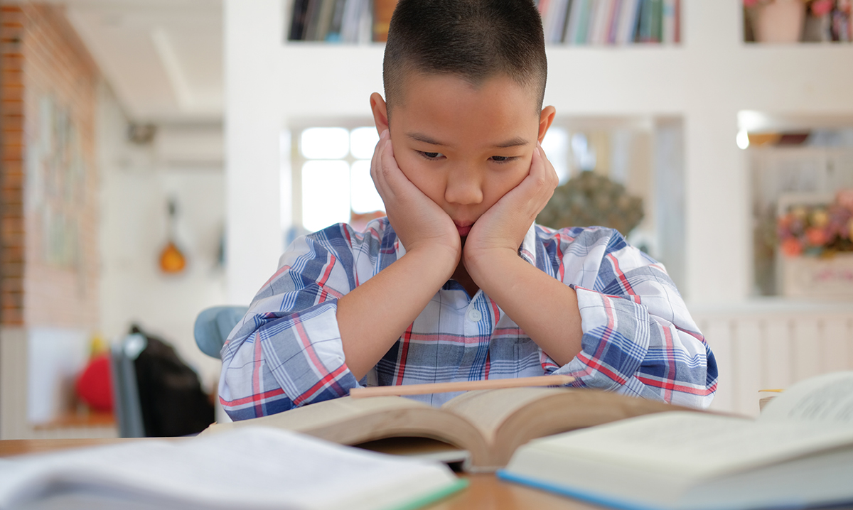 Young boy looks sad while reading