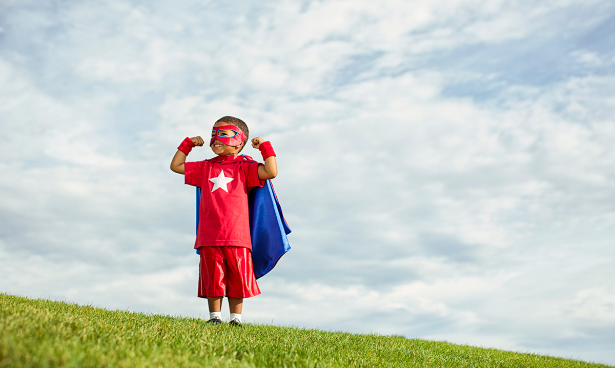 Kid flexing in superhero costume