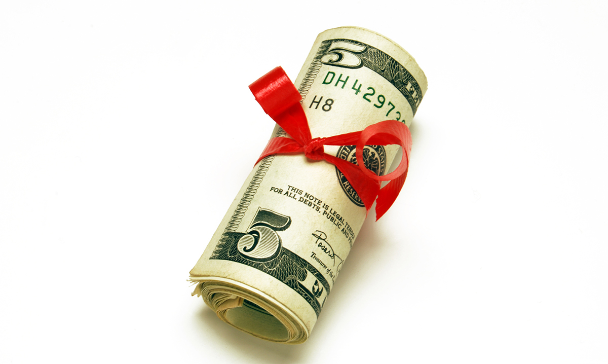 Five dollar bill wrapped in a red ribbon