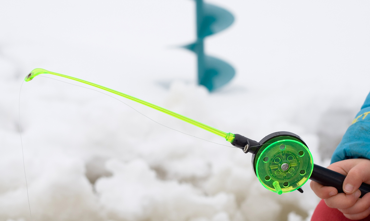 Green kids' fishing pole with snow in the background