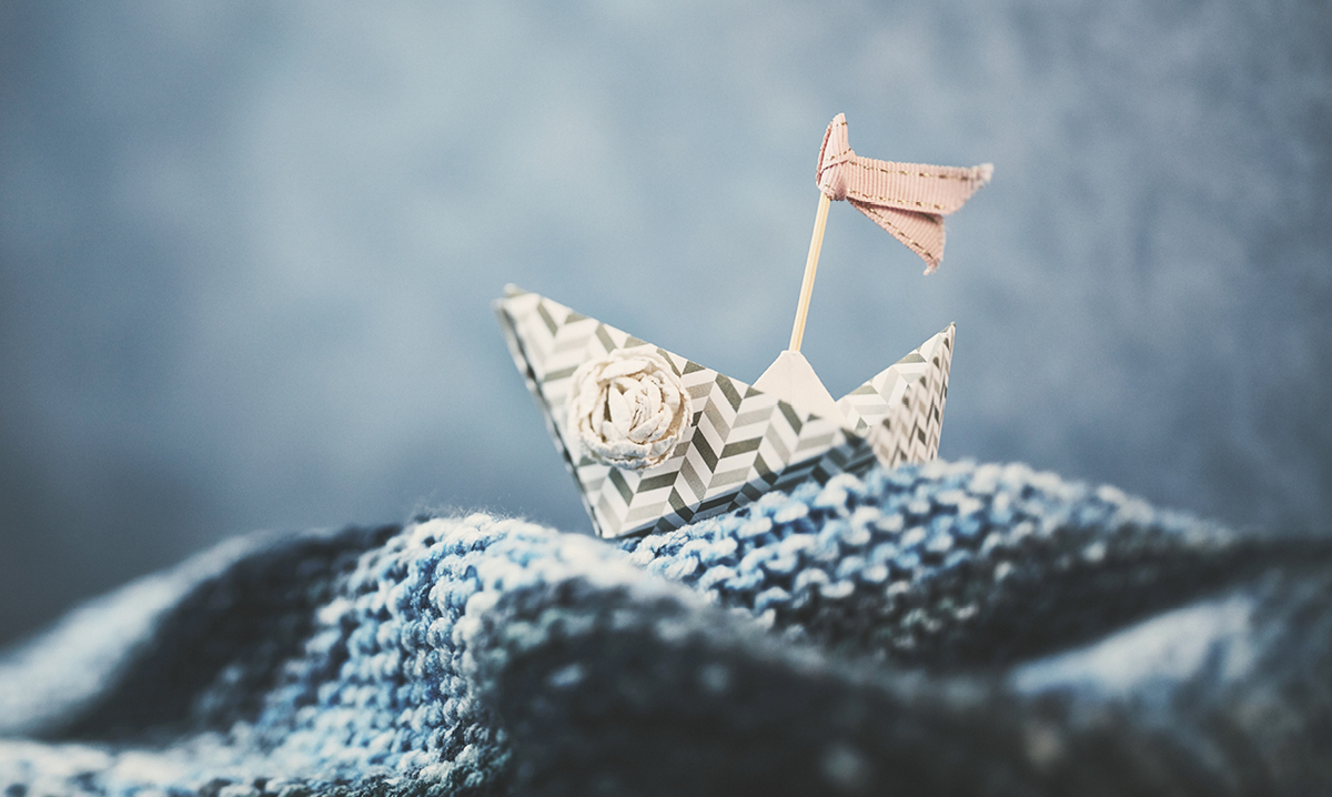 A paper boat on a water blanket