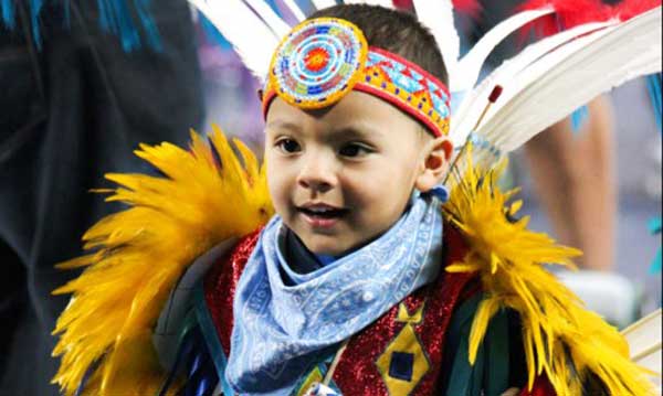 Young boy wearing Native American regalia