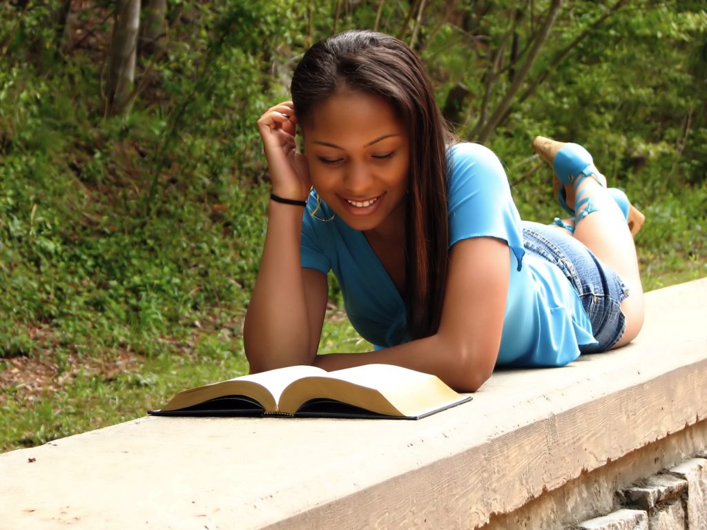 Teen reading and relaxing outside