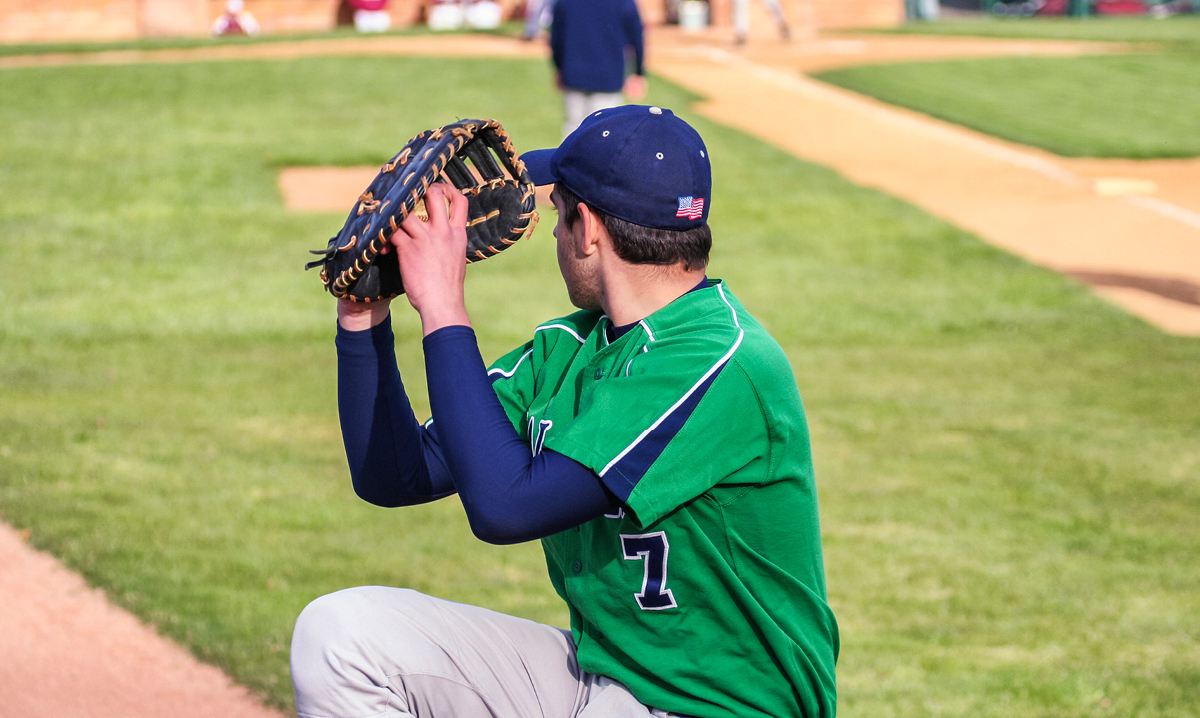 A baseball pitcher winds up to throw the ball