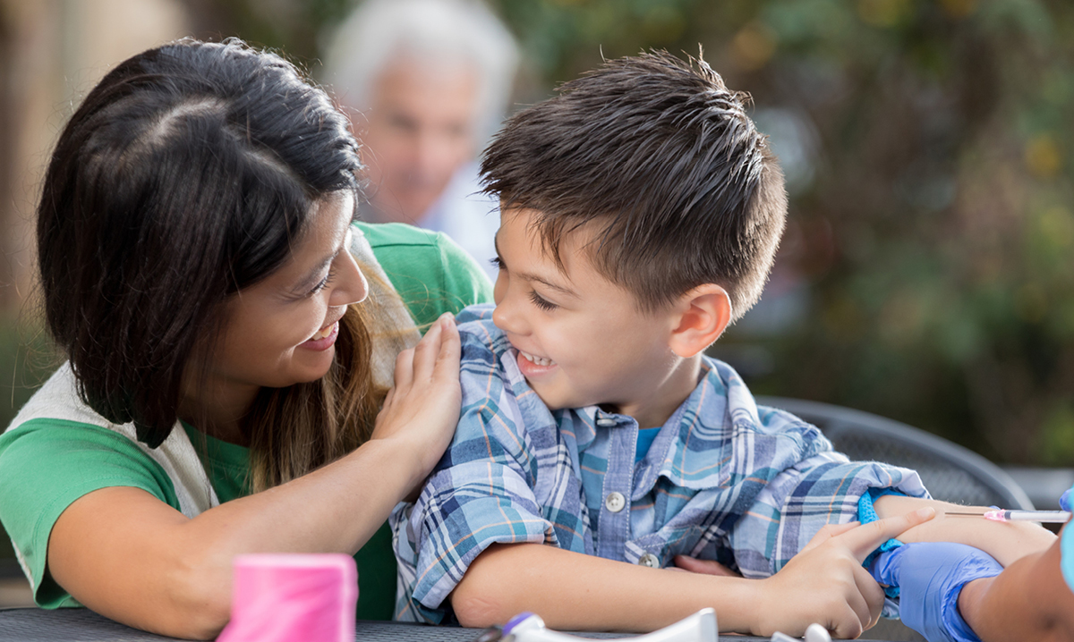 Mom reassures a young boy about to get a vaccination shot