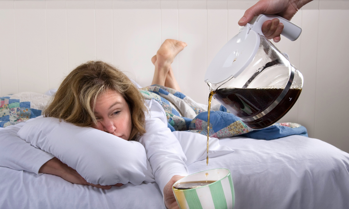Mom in bed holding coffee cup that is being refilled