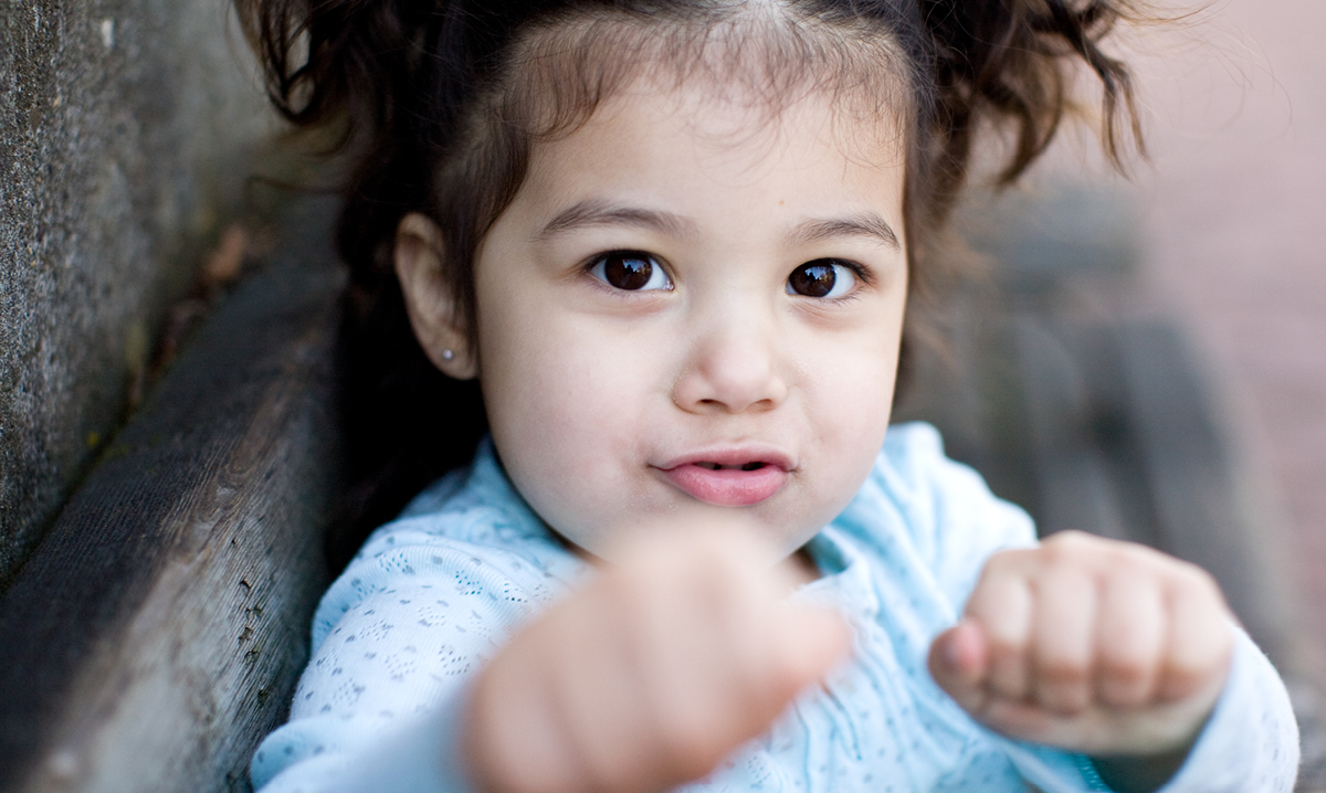 A cute toddler girl with clenched fists