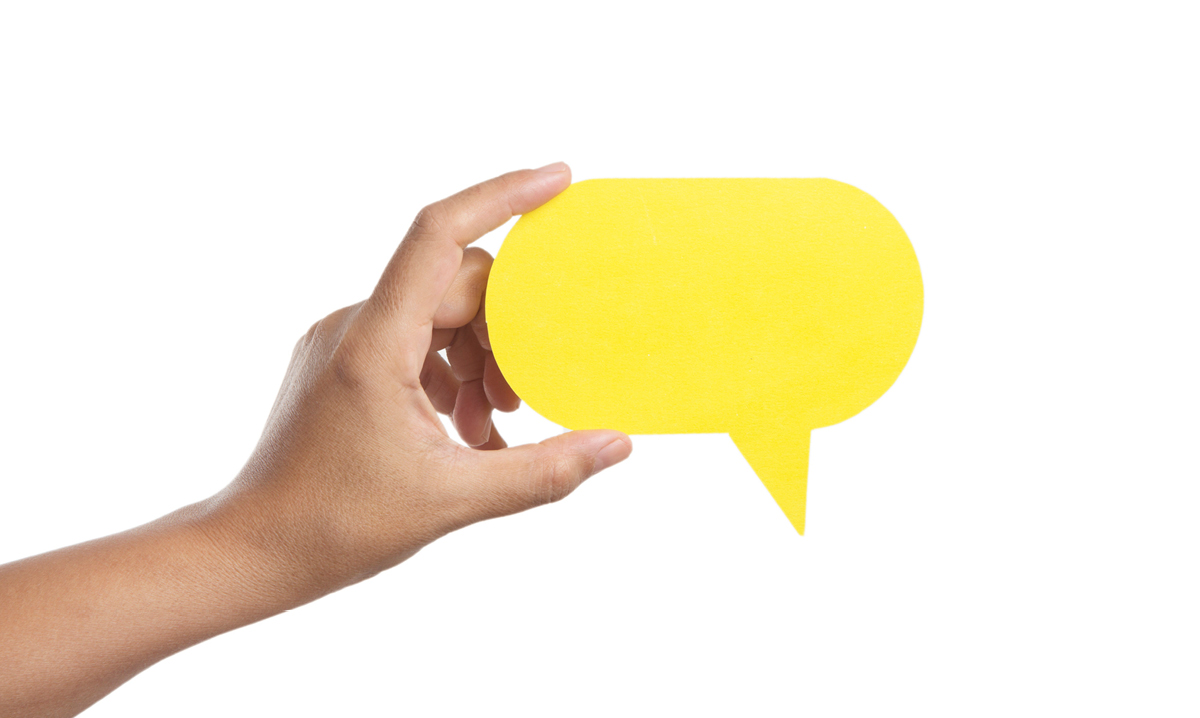 Hand holds up a yellow talking bubble