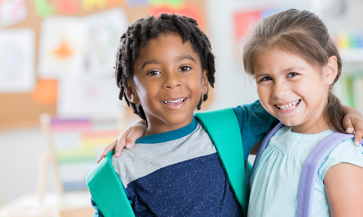 A boy and a girl giving each other a side hug