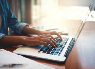 Hands typing on laptop