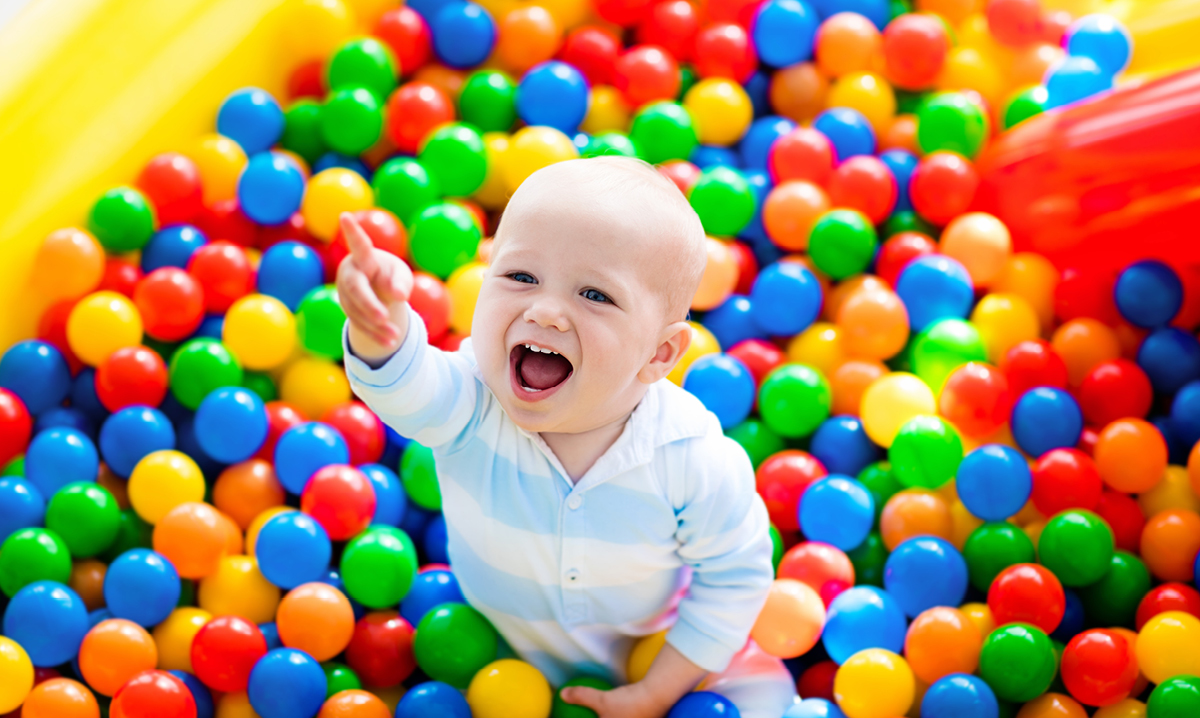 Baby laughing in a ball pit