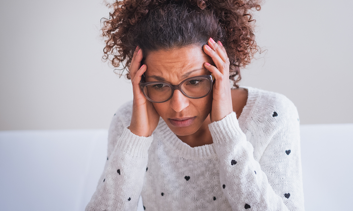 A stressed out woman in a white sweater