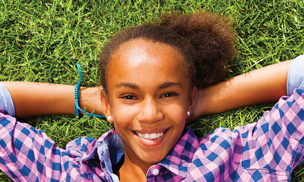 Teen girl reclining on grass