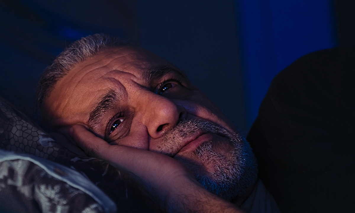 Elderly man worries on his pillow