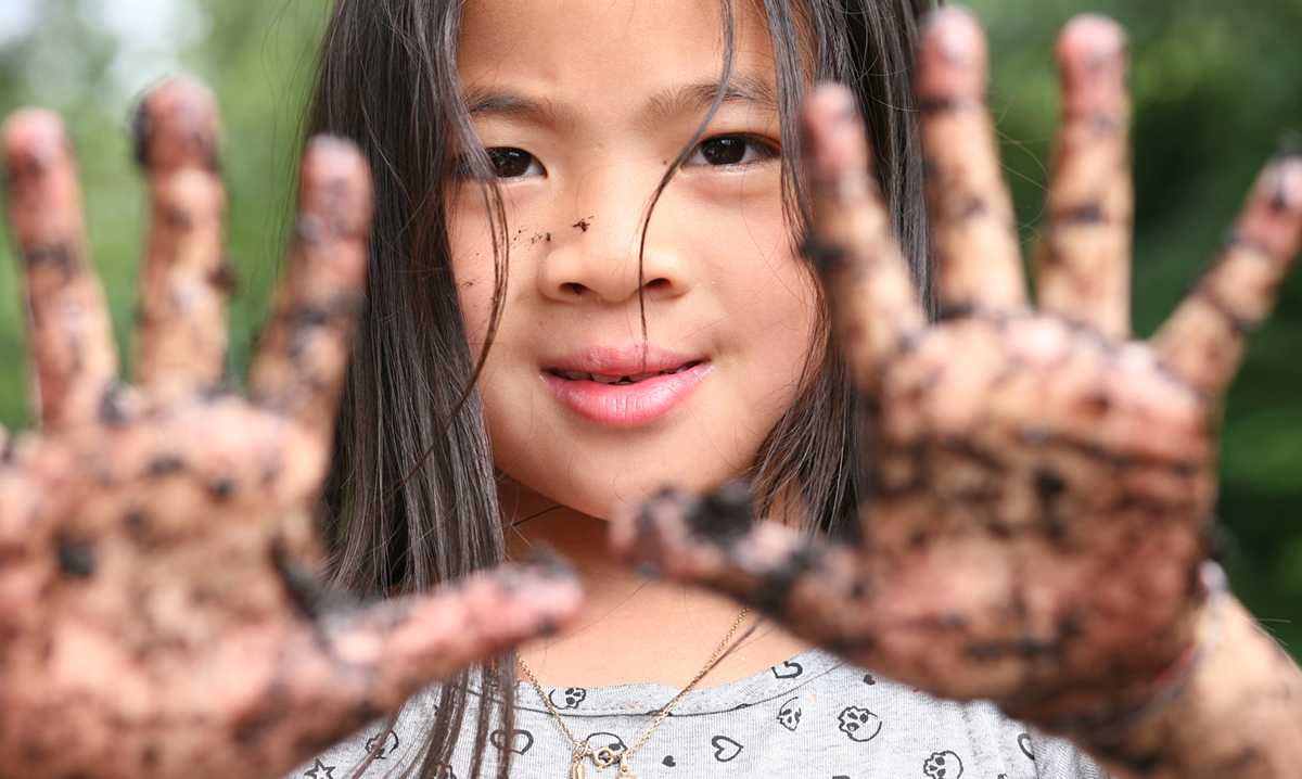 Little girl shows off dirty hands