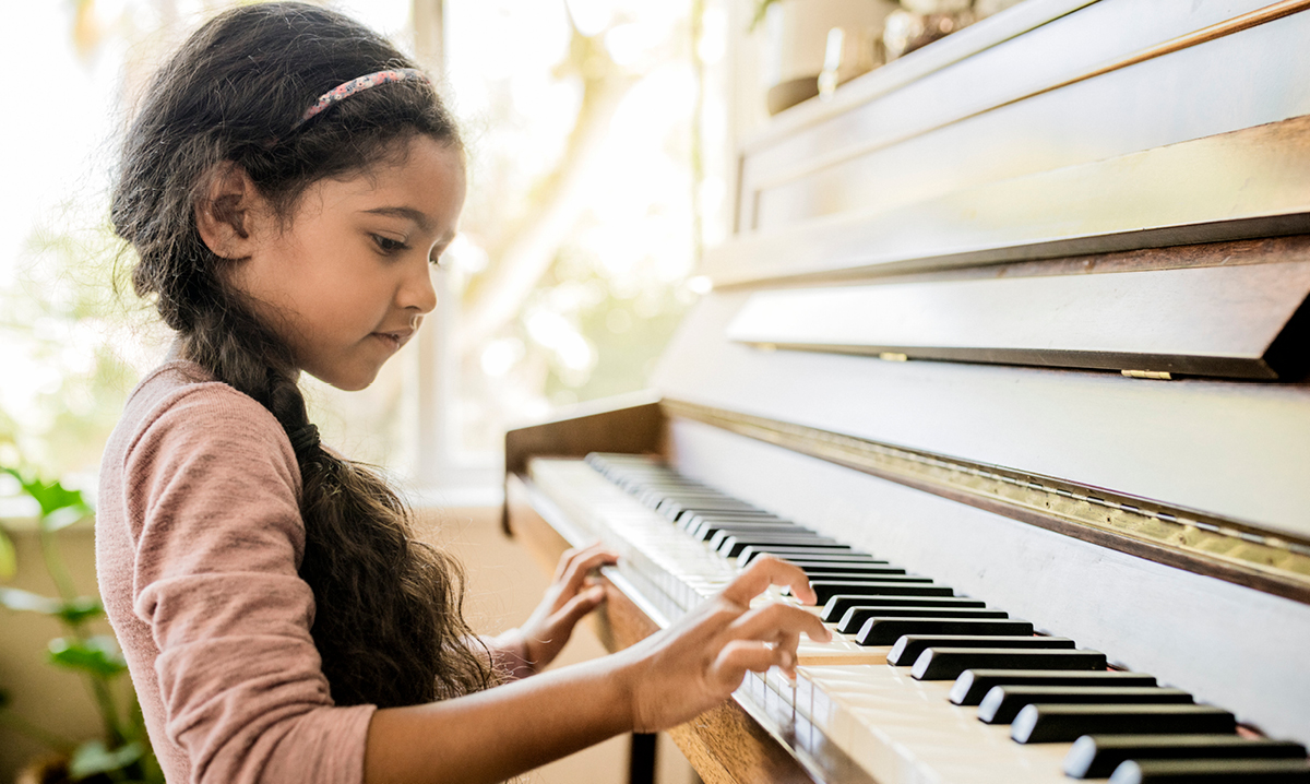 Young girl with long hair playing the piano