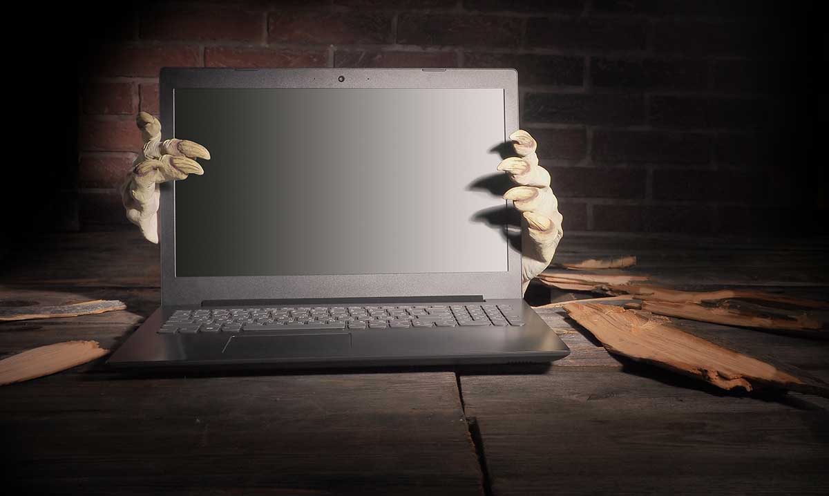 Zombie hands gripping a laptop