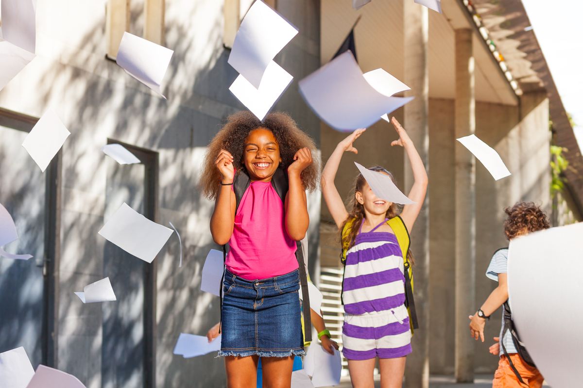 Kids on the last day of school throwing papers in the air