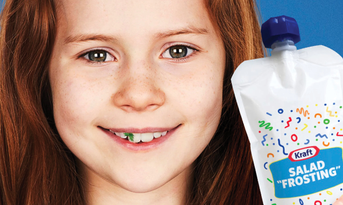 Girl with lettuce stuck in teeth next to package of new salad frosting