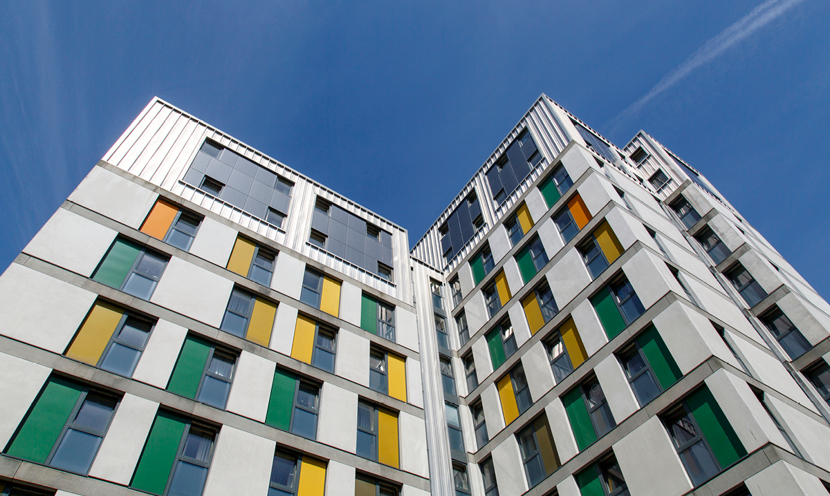 A college dorm with yellow and green accents against a blue sky