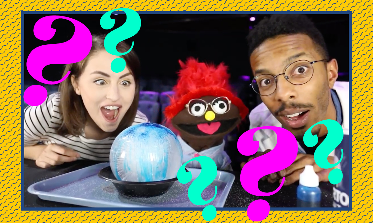 Taylor, Izzy and a scientist excited about the icy cool balloon experiment surrounded by pink and teal question marks