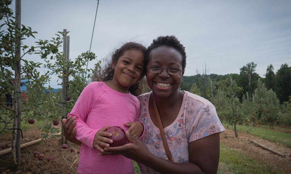 Woman and little girl in apple orchard