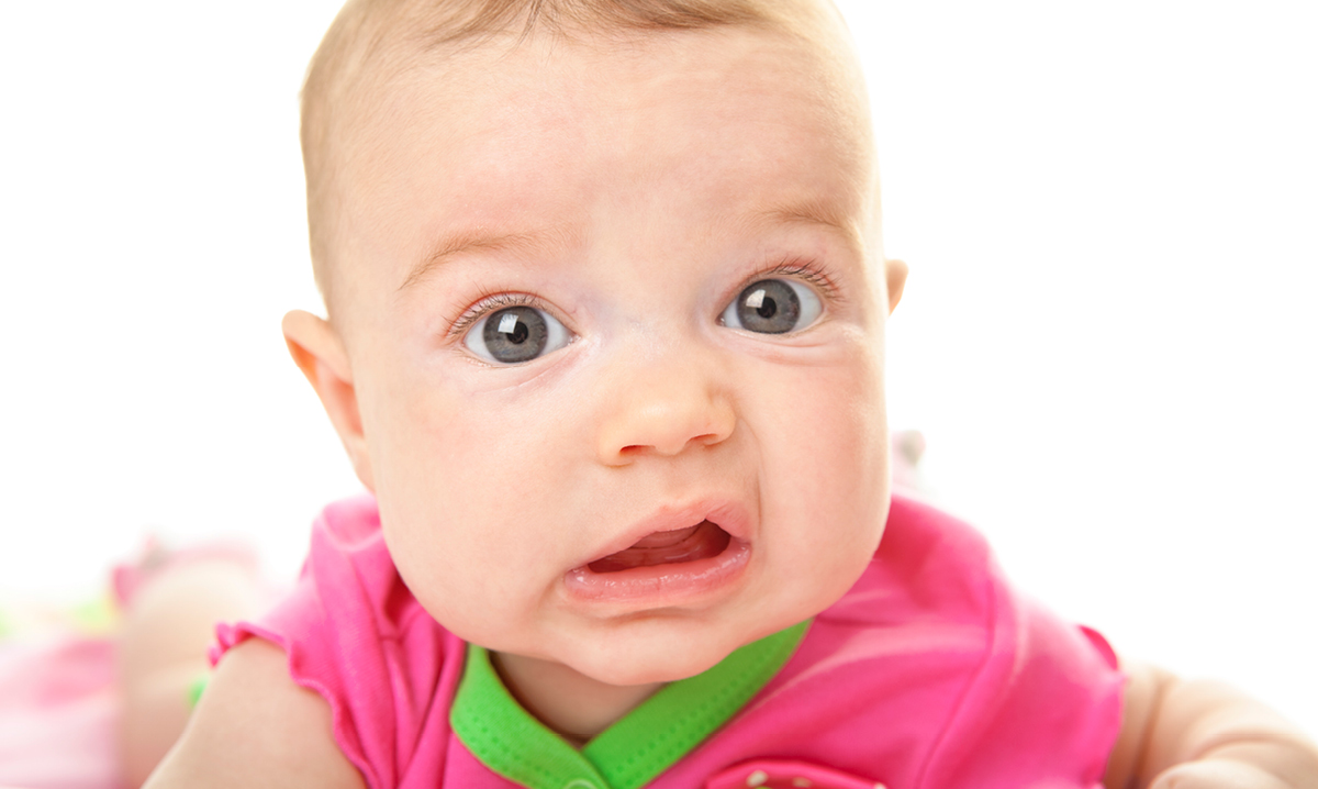 Baby in pink making a funny face