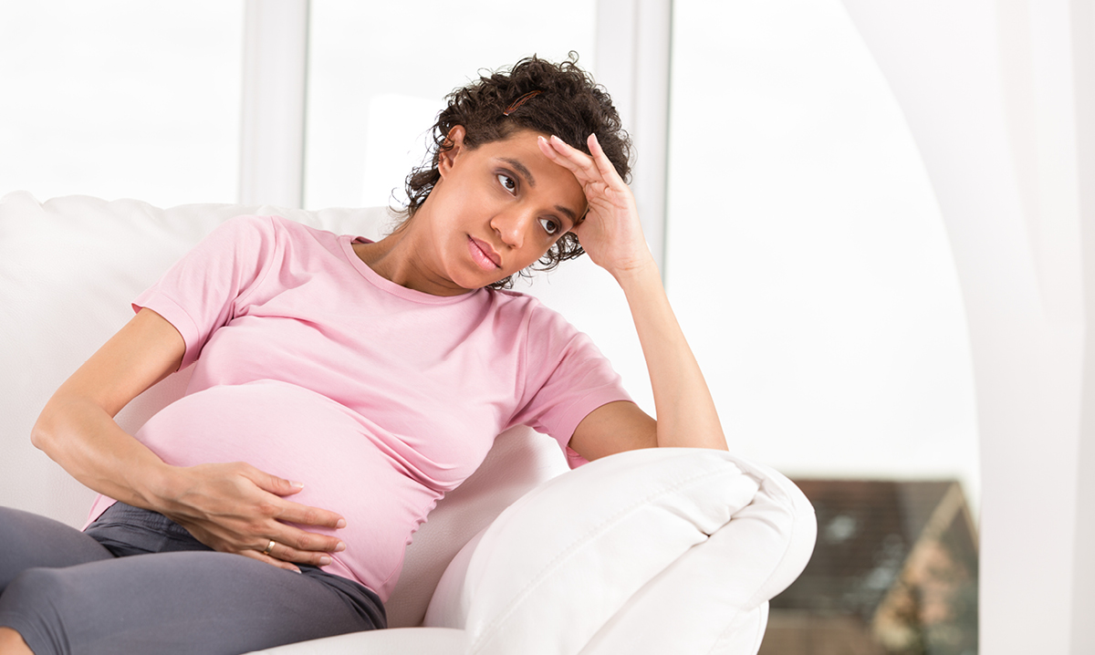 Pregnant women sitting while holding stomach