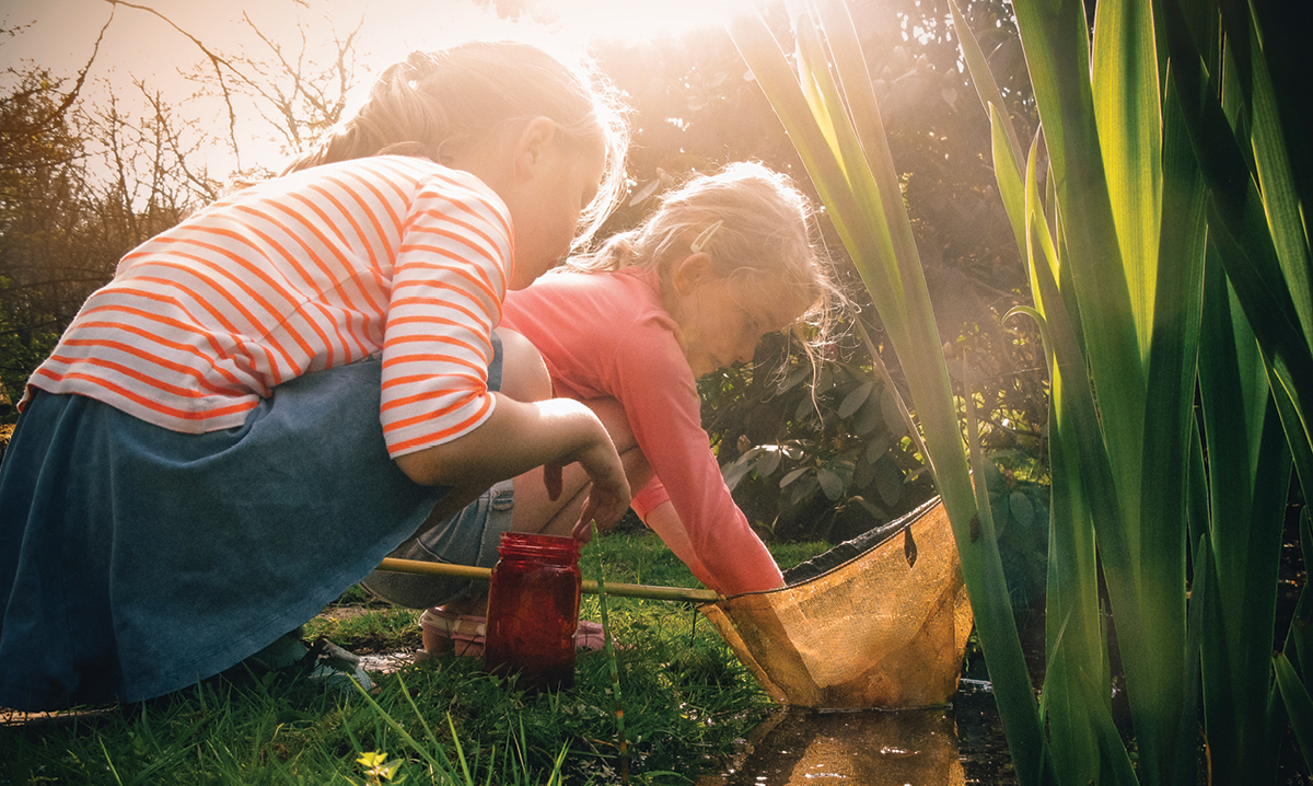 Two girls playing in a pond