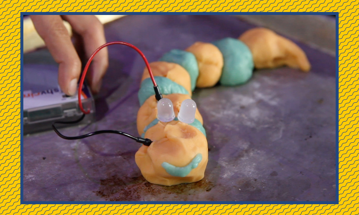 Orange and blue squishy circuits creature on a purple background