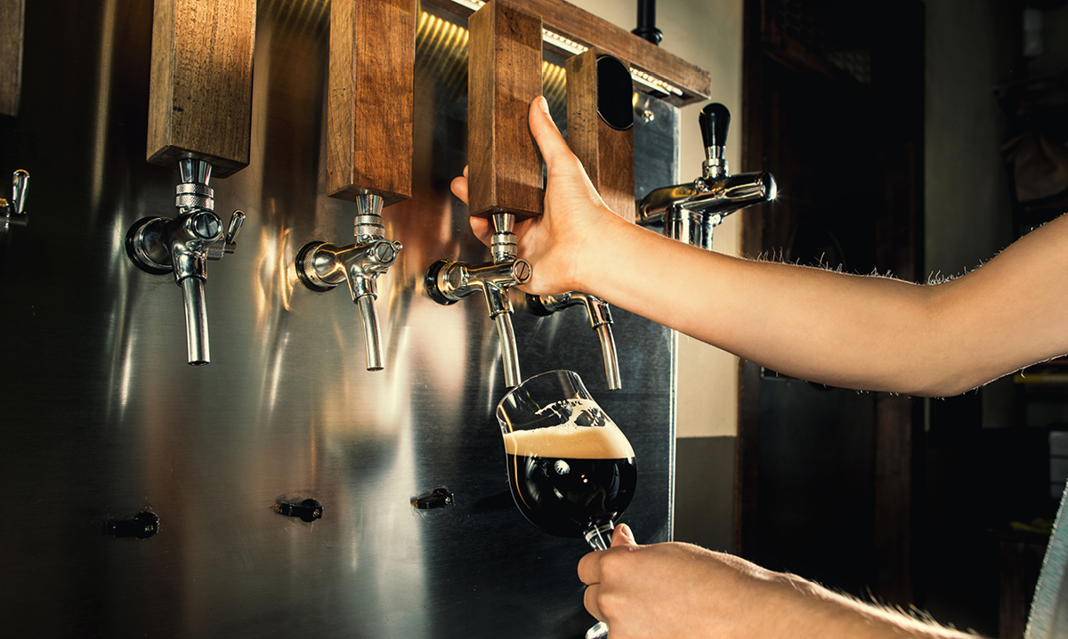 Person pouring a beer from a tap