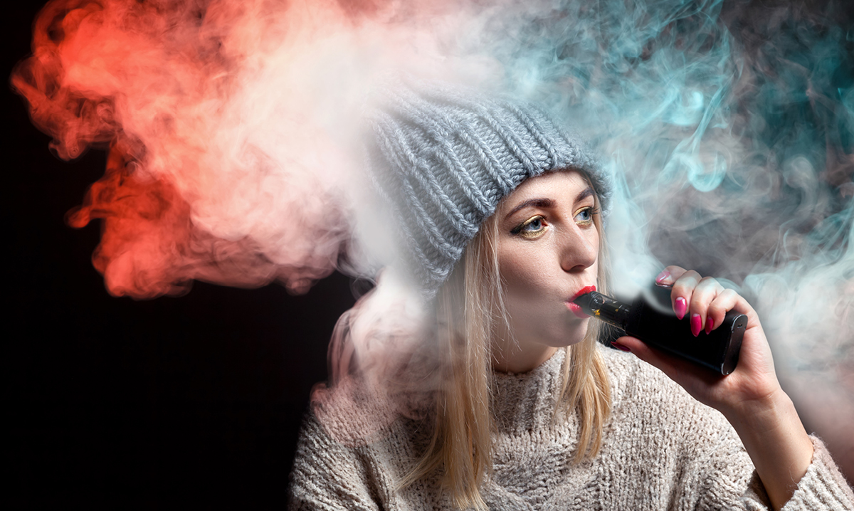 Teen in grey hat smoking e-cigs