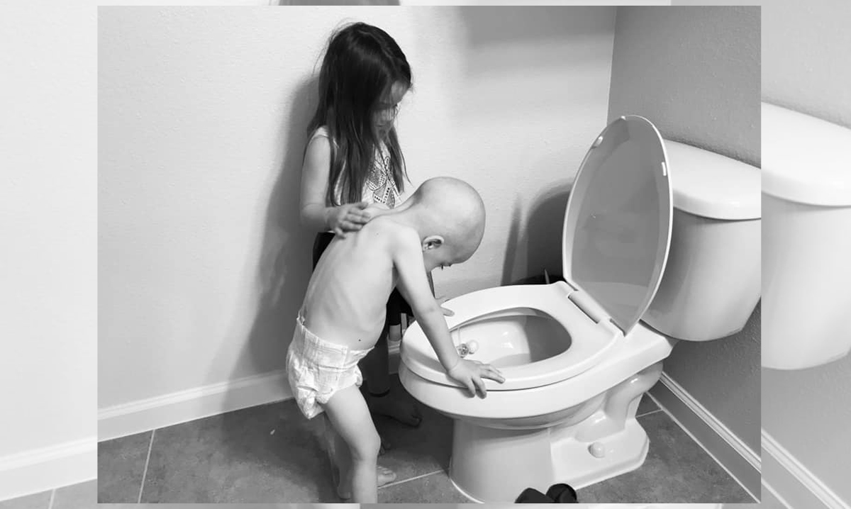 Beckett Burge leans over the toilet while his sister comforts him
