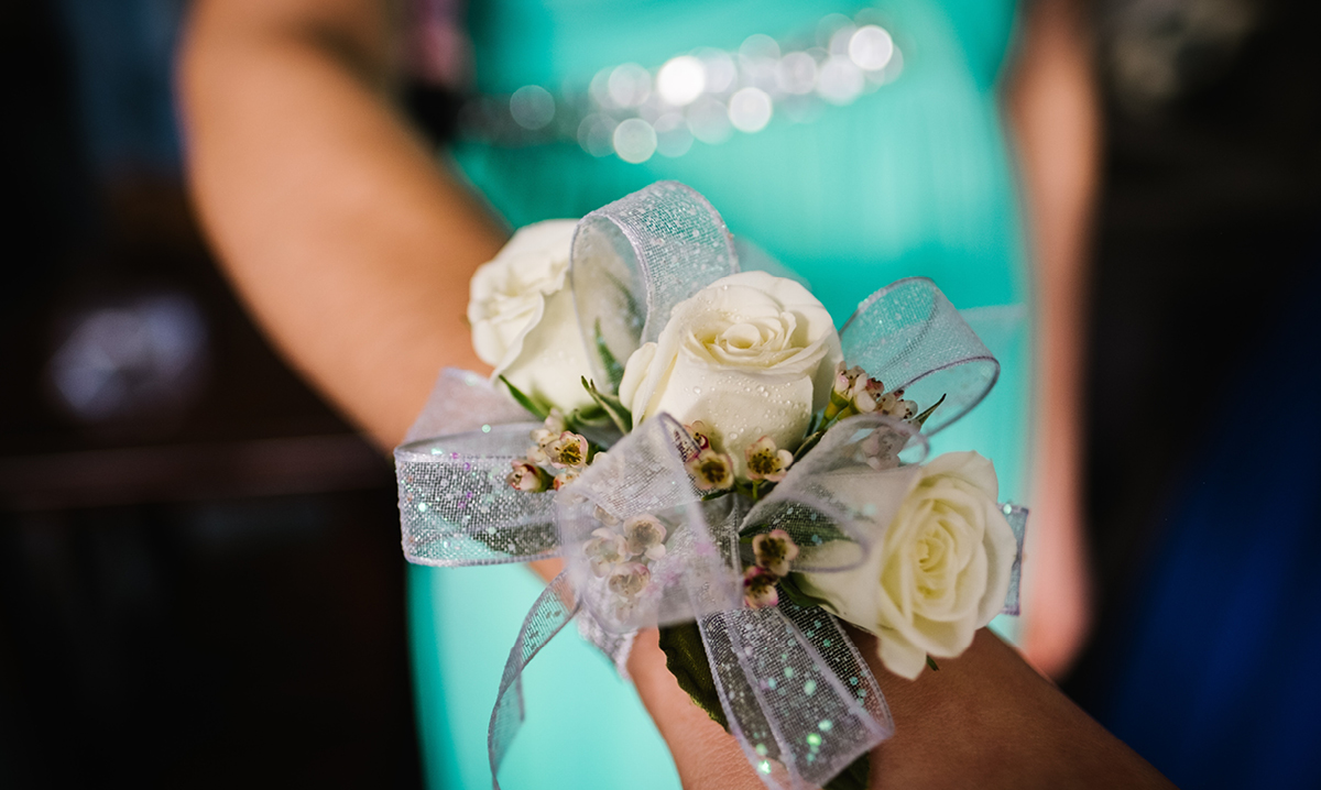 flowers on a wrist with a teal dress in the background