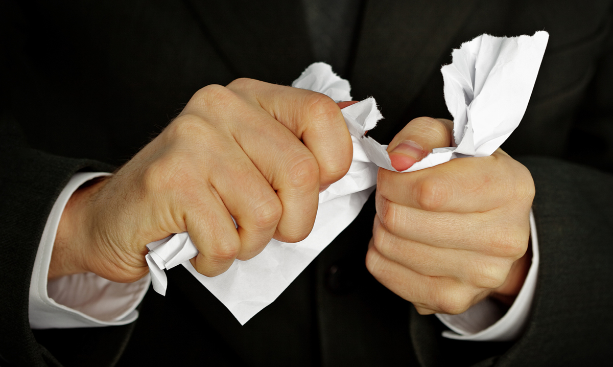 Man hands tearing up paper