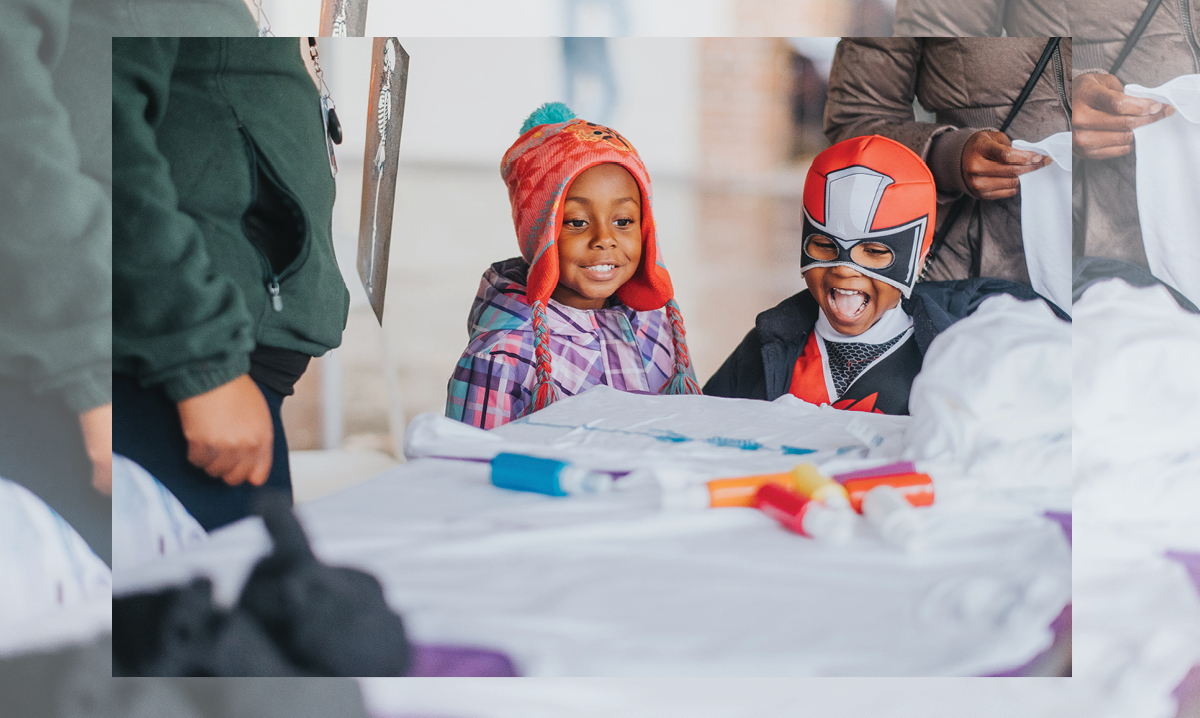 Two children making Halloween crafts in Flint