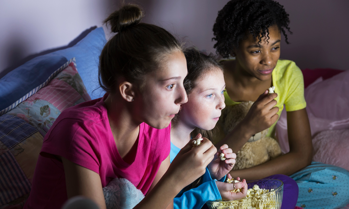 Three girls eating popcorn