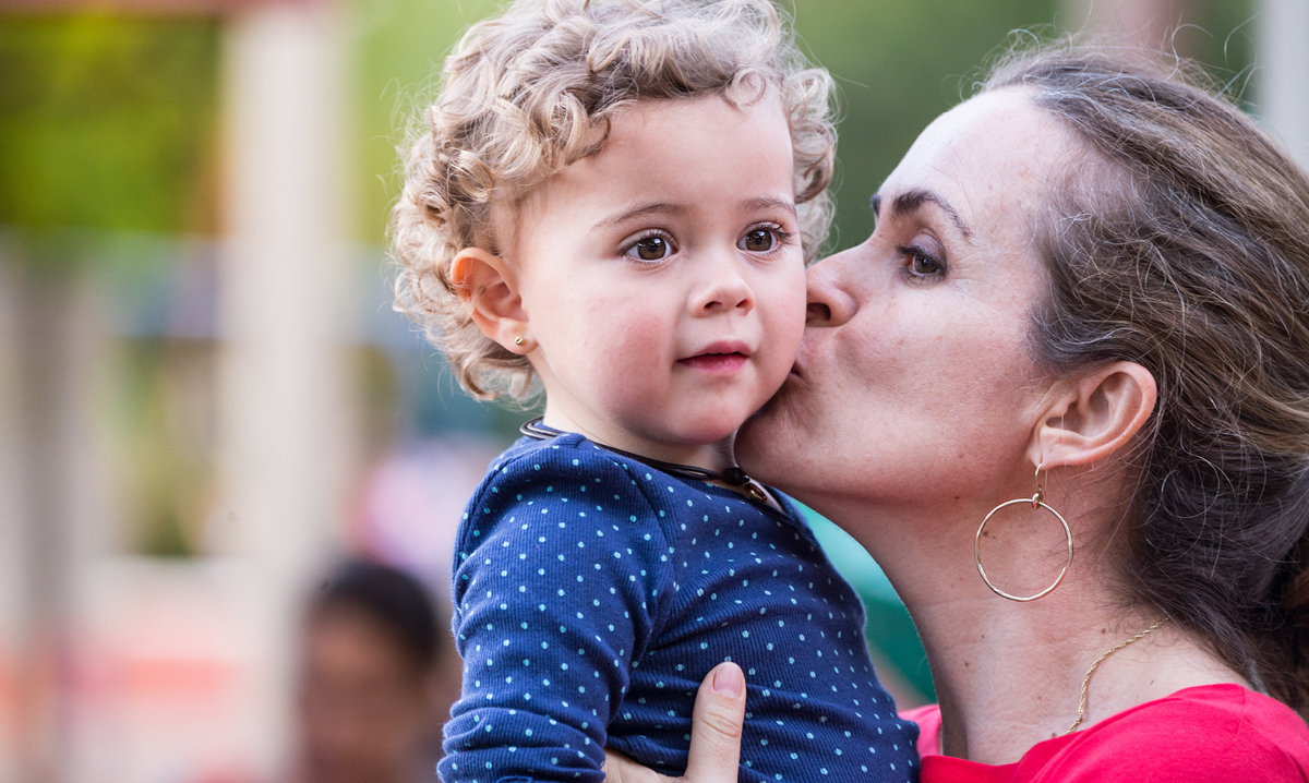 Mom kissing daughter on the cheek