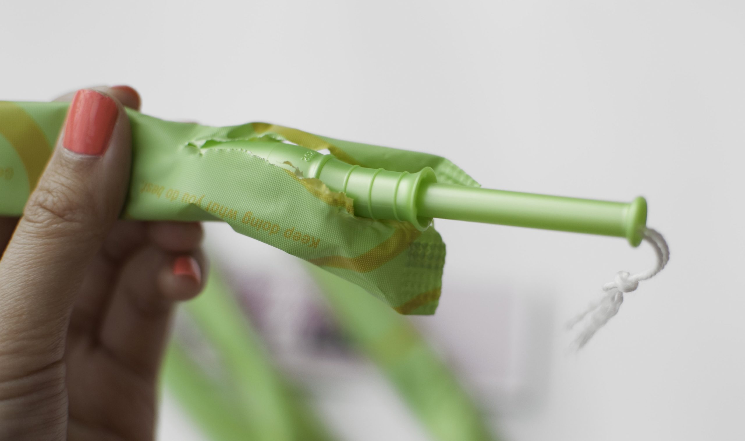 hand holding an unwrapped tampon