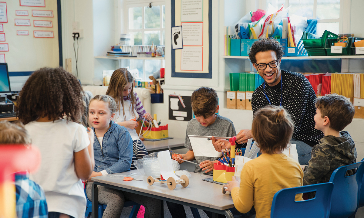 Kid in a classroom surrounded by science projects