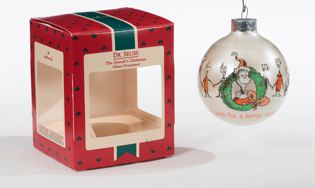 Grinch ornament and box on a white background